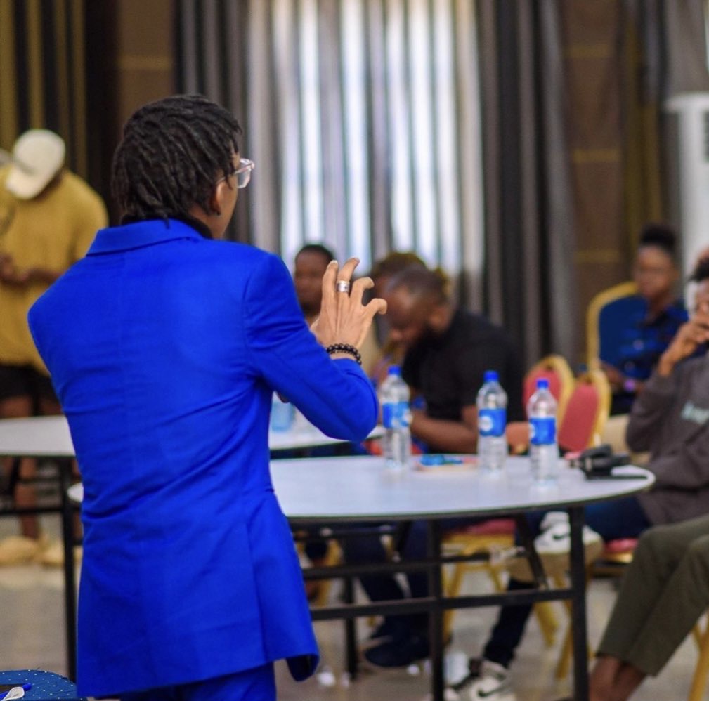 man in blue suit addressing people